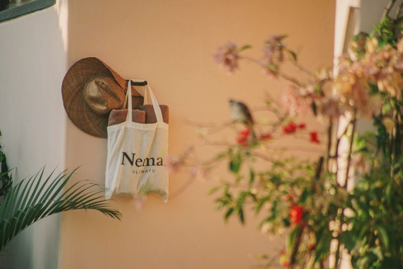 A Nema. tote, a straw hat and climbing flowers